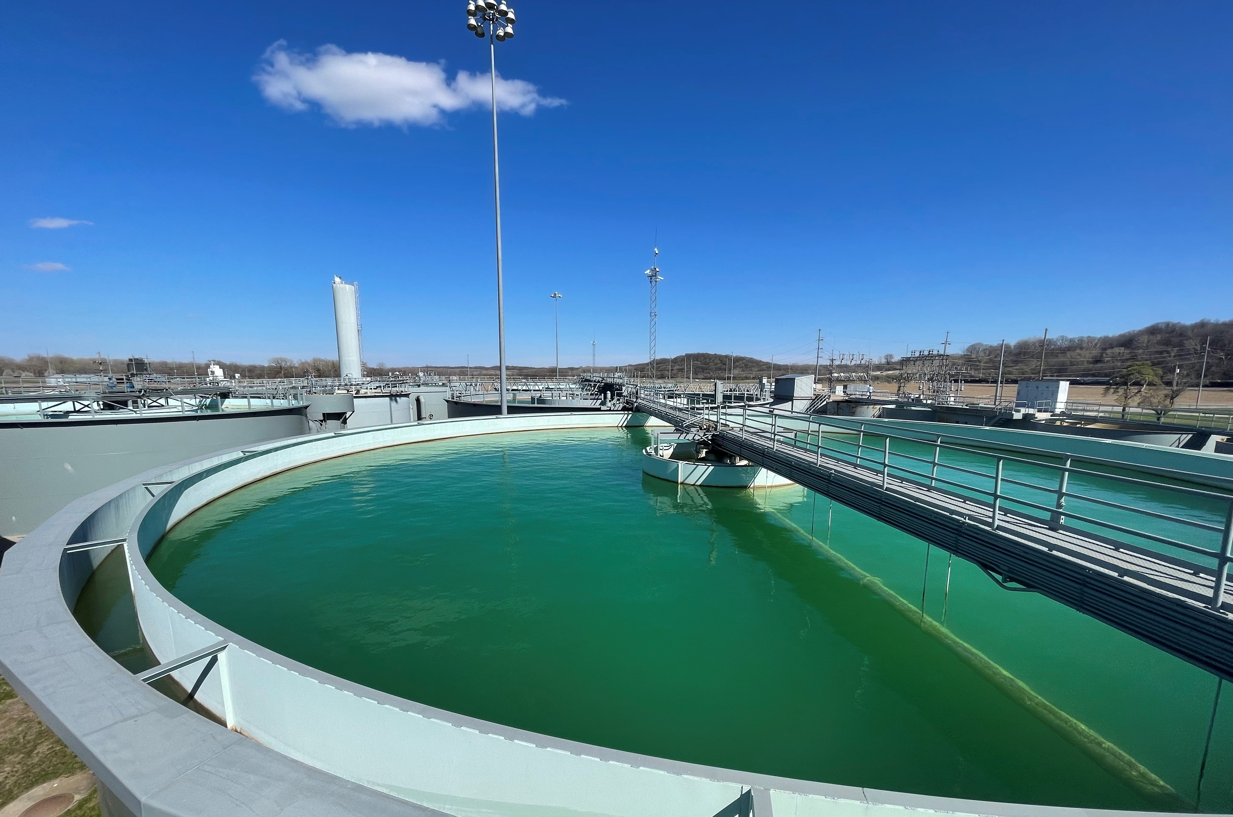 A water tank filled with green-tinted water and a bright clear sky