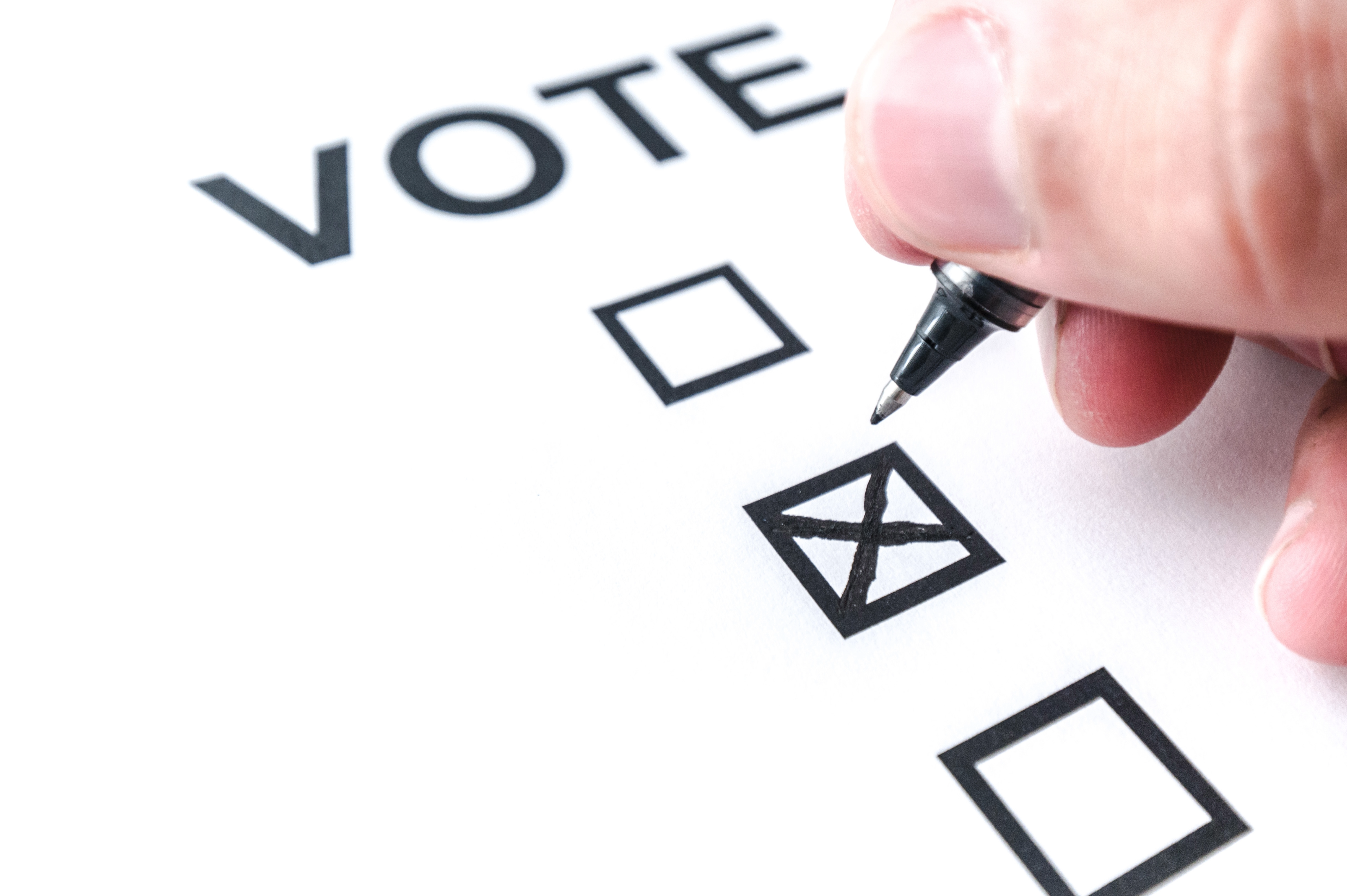 Blank stock image of a Ballot with a hand marking an X vote