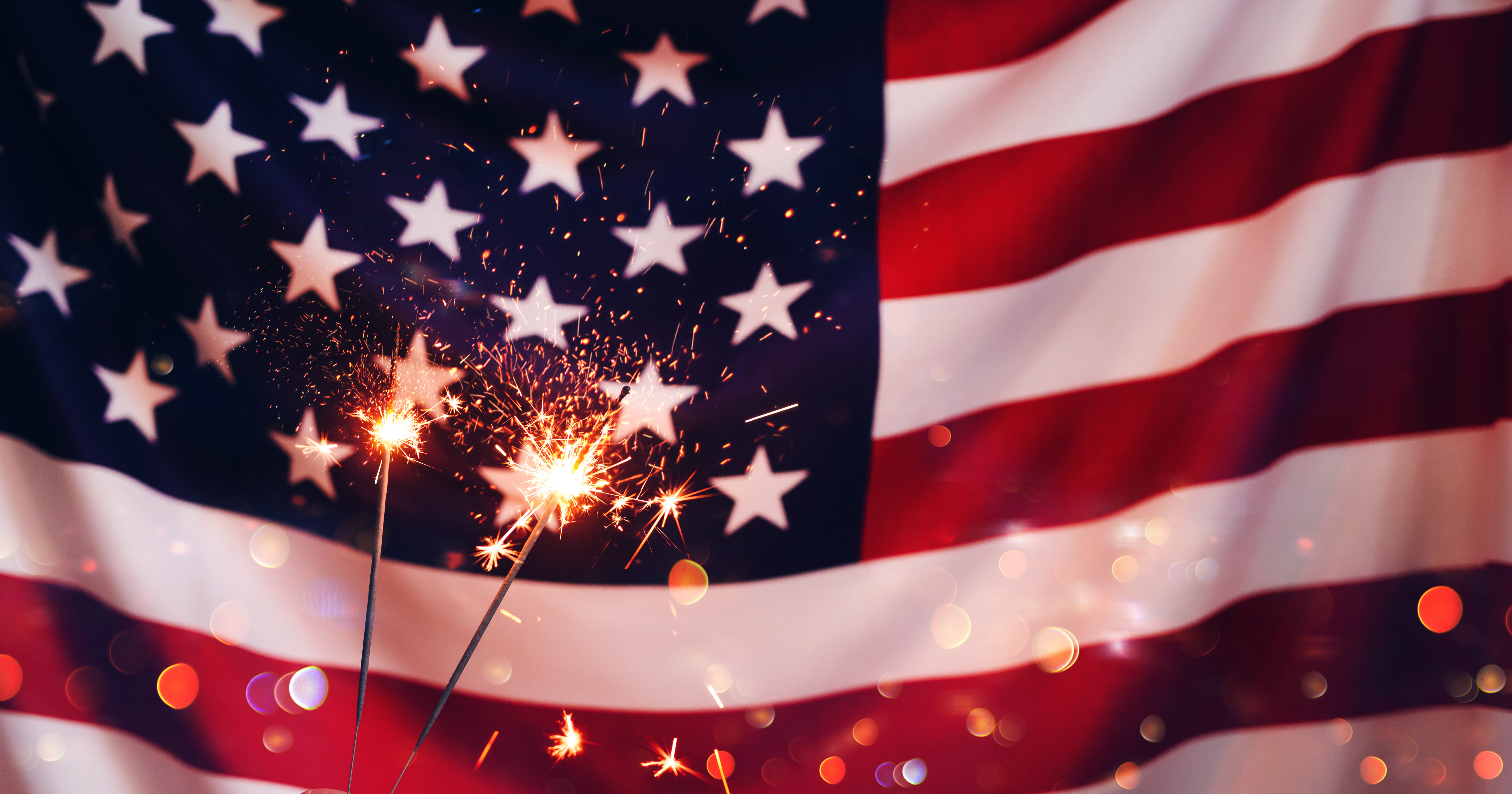 Photo of the American flag with sparklers in front of it