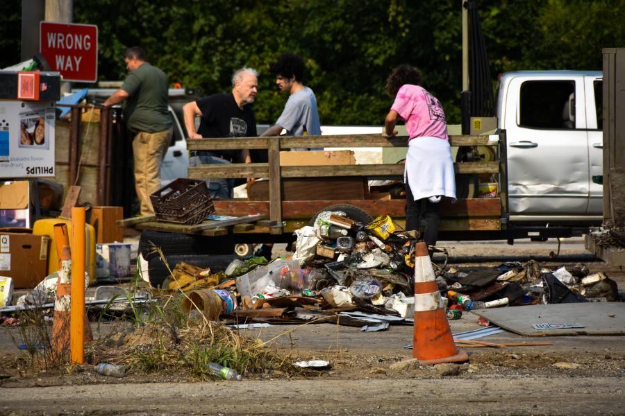 Residents remove items from a truck bed at the Drop-off Depot refuse collection event. 