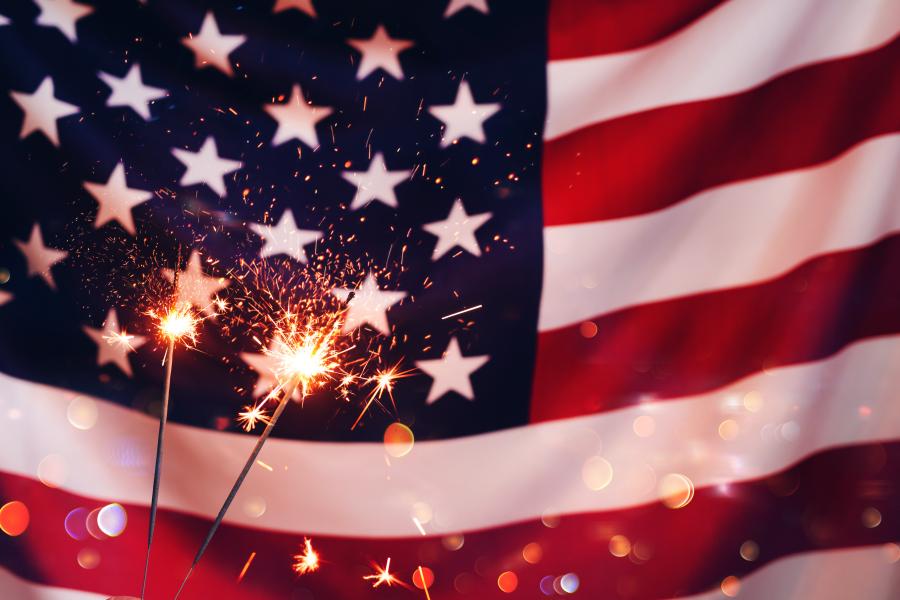 Photo of the American flag with sparklers in front of it