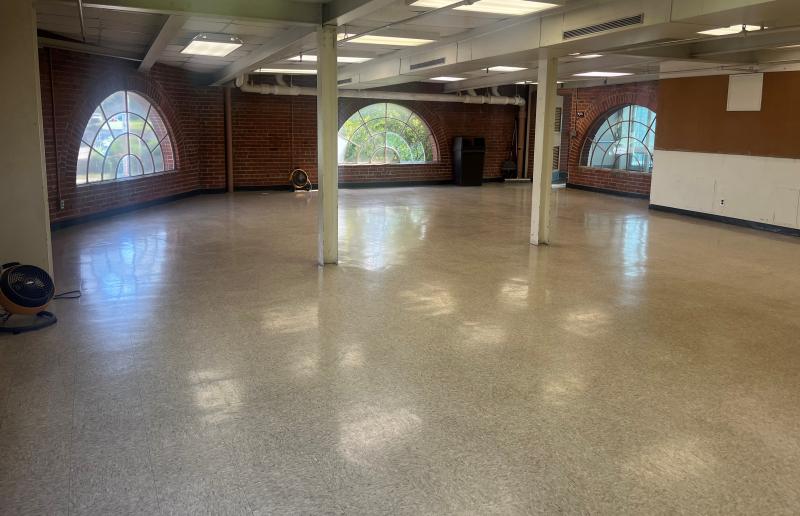 An image of inside the 4th floor room at the Sermon Center facing South with crescent shaped windows and a tile floor.