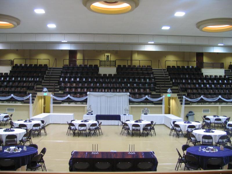 view of TMB auditorium from stage perspective fully set-up with tables and chairs