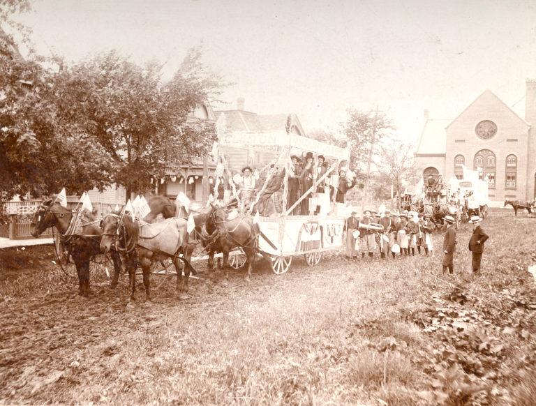 A historic, black and white image of a wagon leaving Independence