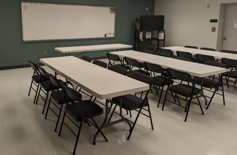 A picture of rectangle tables and folding chairs set up in the Palmer Center Park Place Meeting Room 