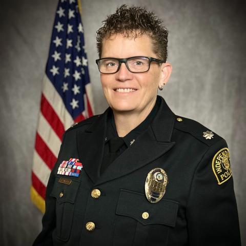 Photo of Independence Police Department Deputy Chief Michelle Sumstad in full IPD uniform with an American flag in the background.