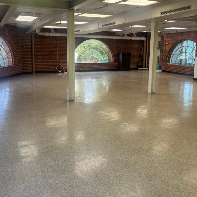 An image of inside the 4th floor room at the Sermon Center facing South with crescent shaped windows and a tile floor.